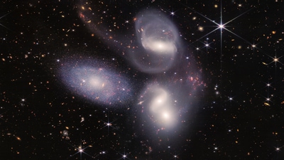 Sparkling clusters of millions of young stars and starburst regions of fresh star birth grace the image. Sweeping tails of gas, dust and stars are being pulled from several of the galaxies due to gravitational interactions. (NASA, ESA, CSA, STScI) Sparkling clusters of millions of young stars and starburst regions of fresh star birth grace the image. Sweeping tails of gas, dust and stars are being pulled from several of the galaxies due to gravitational interactions. (NASA, ESA, CSA, STScI)