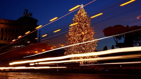 A bus passes in front of a solar-powered Christmas tree in Piazza Venezia in Rome, Italy, on December 23.&nbsp;(Guglielmo Mangiapane / Reuters)