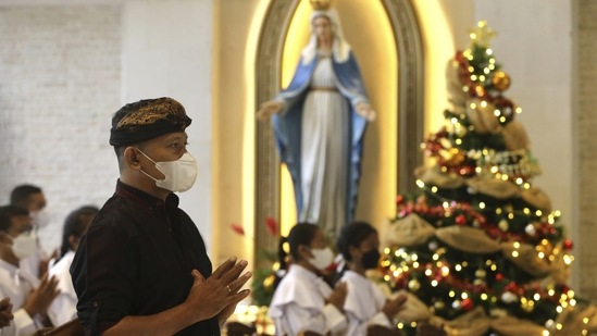 A man is seen praying during a Christmas Eve service at a cathedral in Denpasar, Bali, on December 24.(Firdia Lisnawati / AP)