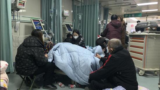Relatives gather near the bed of a sick patient at the emergency department of the Langfang No 4 People’s Hospital in Bazhou city in northern China'\’s Hebei province on Thursday. (AP)