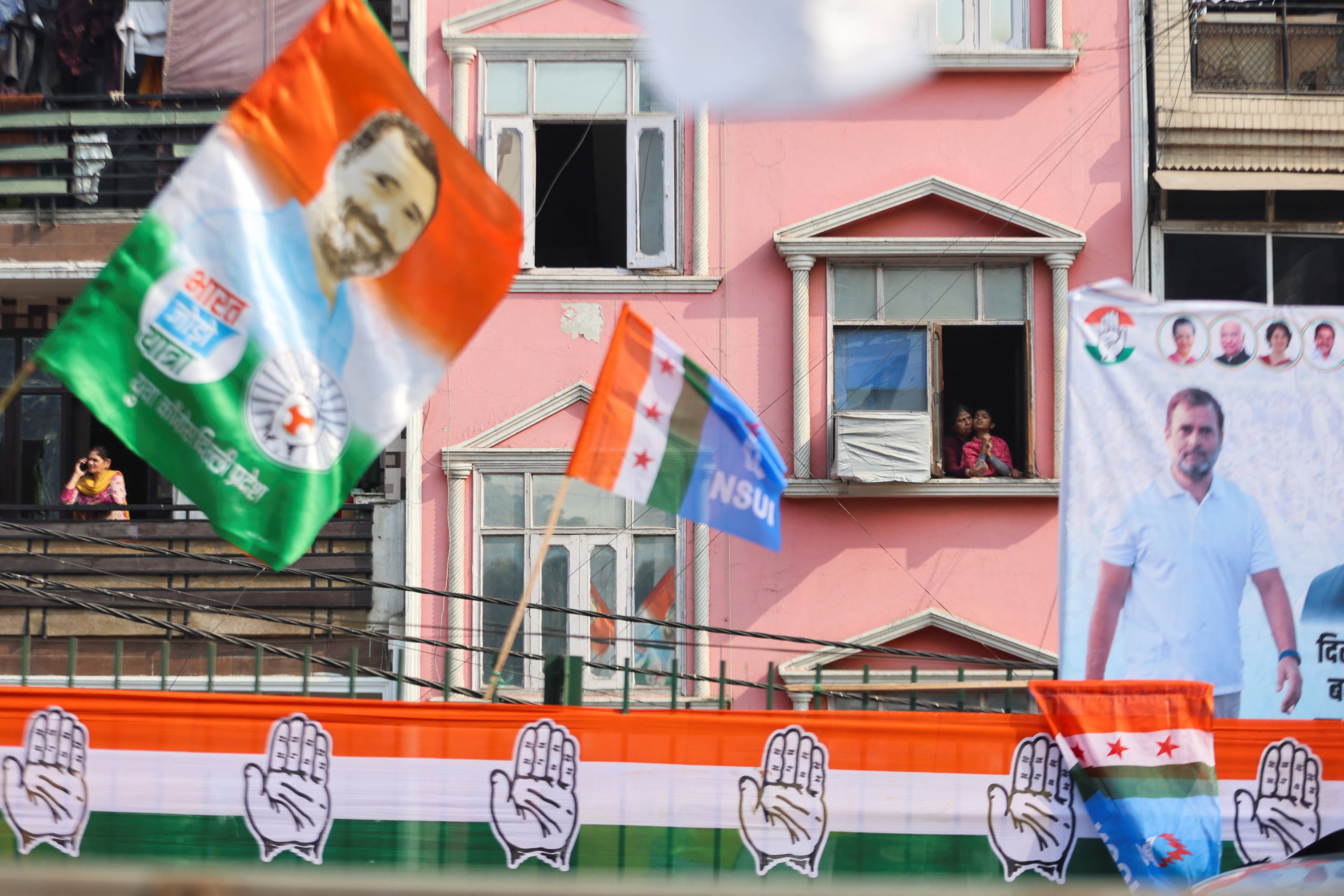 Women are seen at the window as they wait for the Bharat Jodo Yatra to pass by. (REUTERS)