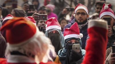 A group of people participates in Christmas celebrations at the Holy Family Catholic Church in Srinagar on Sunday. (PTI)