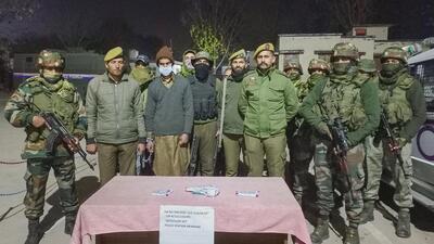 Jammu and Kashmir Police with the alleged militant associate along with pistol and ammunition in Mendhar area of Poonch on Sunday. (PTI)