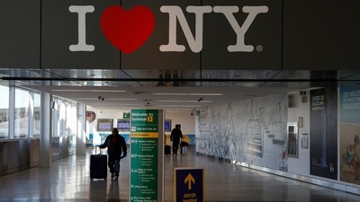 New York Airport: Air travellers wearing protective face masks, amid the coronavirus disease (COVID-19) pandemic, walk at JetBlue Terminal 5 at JFK International airport in New York. (Reuters File)