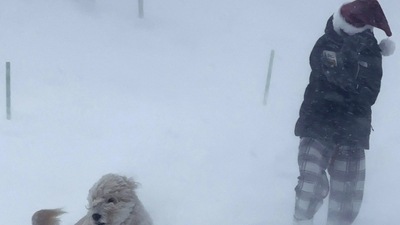 Lyla Kelly plays with her dog Maggie in the snow during a winter storm that hit the Buffalo region in East Amherst, New York. (via REUTERS)