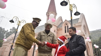 A boy wishes police officers in Amritsar, Punjab, while sharing apparently some food with them. (Sameer Sehgal/HT Photo) A boy wishes police officers in Amritsar, Punjab, while sharing apparently some food with them. (Sameer Sehgal/HT Photo)