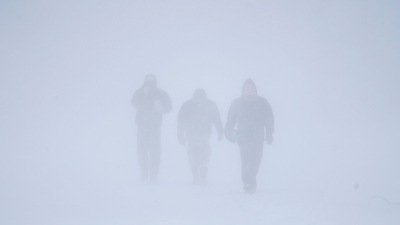Three men walk down Richmond Avenue in whiteout conditions during a sustained blizzard in Buffalo, New York. (The Buffalo News via AP) Three men walk down Richmond Avenue in whiteout conditions during a sustained blizzard in Buffalo, New York. (The Buffalo News via AP)