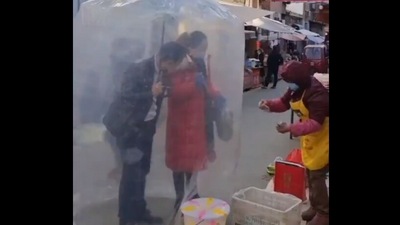 A viral video posted by China state-affiliated media, People’s Daily, shows a couple shopping for vegetables while protecting themselves from the risk of getting infected in an innovative way. (Twitter/@PDChina)