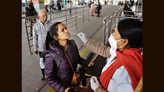 A medic takes swab sample from an air passenger for Covid-19 test at the Birsa Munda International Airport in Ranchi on Sunday amid a surge in coronavirus cases in some countries. (PTI) A medic takes swab sample from an air passenger for Covid-19 test at the Birsa Munda International Airport in Ranchi on Sunday amid a surge in coronavirus cases in some countries. (PTI)