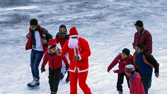 A man dressed as Santa Claus on Christmas skates with other students at an ice-skating rink at Lakkar Bazar in Shimla on Sunday.(PTI)