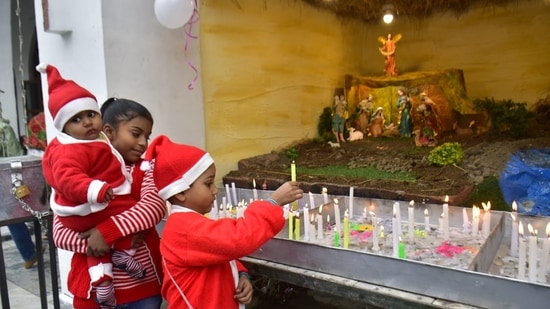 Children light candles at a church in Chandigarh on Sunday.(Keshav Singh/HT Photo)