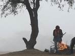 People huddle around a bonfire to warm themselves on a cold morning at Dwarka, in New Delhi, on December 24. On December 25, Delhi recorded the season’s first coldwave conditions taking both the maximum and minimum temperatures to this winter’s lowest so far, HT reported.(Vipin Kumar / HT Photo)