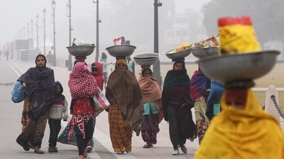 Workers wearing warm clothes are seen at Kartavya Path on a cold winter morning, in New Delhi on December 26. The IMD classifies it as a cold day when the maximum temperature is 4.5 degrees or more below normal, while the minimum is below 10 degrees Celsius.&nbsp; (Amit Sharma / ANI)