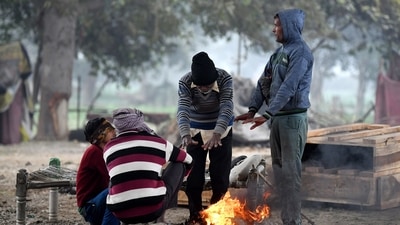 People gather around a bonfire to keep themselves warm on a cold winter morning, at Yamuna Khadar, in New Delhi. (ANI) People gather around a bonfire to keep themselves warm on a cold winter morning, at Yamuna Khadar, in New Delhi. (ANI)