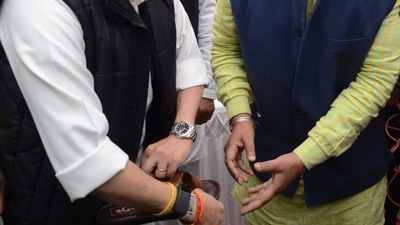 Union minister Jyotiraditya Scindia gives slippers to wear to MP minister Pradyuman Singh Tomar. Union minister Jyotiraditya Scindia gives slippers to wear to MP minister Pradyuman Singh Tomar.
