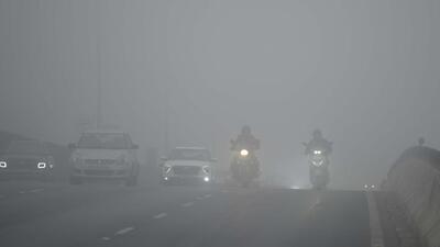 Gurugram, India-December 26, 2022: Commuters drive at slow speed with light amid cold and dense foggy morning at the Delhi-Gurugram expressway near income tax building, in Gurugram, India, on Monday, 26 December 2022. (Photo by Parveen Kumar/Hindustan Times)