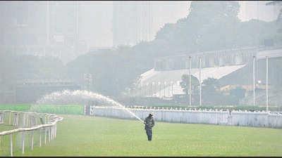 Mumbai, India - December 07, 2022: A worker waters the racecourse lawn while the city is engulfed in smog amid hazy weather, at Mahalaxami, in Mumbai, India, on Wednesday, December 07, 2022. (Photo by Bhushan Koyande/HT Photo) (HT PHOTO)