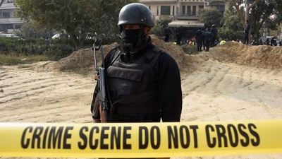 A police officer stands inside cordoned-off area after a suicide car bombing in Islamabad, Pakistan, on December 23. (REUTERS)