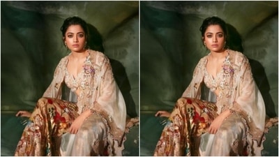 Rashmika decked up in an ivory white embroidered blouse with sleeveless details and coset patterns. She further teamed it with a pair of sharara featuring multicloured floral details throughout. In an ivory white laced shrug featuring zari details at the borders, Rashmika rounded off the look. (Instagram/@rashmika_mandanna) Rashmika decked up in an ivory white embroidered blouse with sleeveless details and coset patterns. She further teamed it with a pair of sharara featuring multicloured floral details throughout. In an ivory white laced shrug featuring zari details at the borders, Rashmika rounded off the look. (Instagram/@rashmika_mandanna)