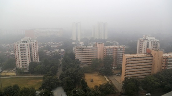 A view of high-rise buildings engulfed in dense smog in New Delhi, on December 26. The IMD declares a coldwave in a region when the minimum temperature is 4.5 degrees or more below the normal mark, or when it drops to 4 degrees Celsius or lower. Both the Ridge (3 degrees) and Ayanagar (3.5 degrees) stations met this criterion on December 25, but Safdarjung did not.(PTI)