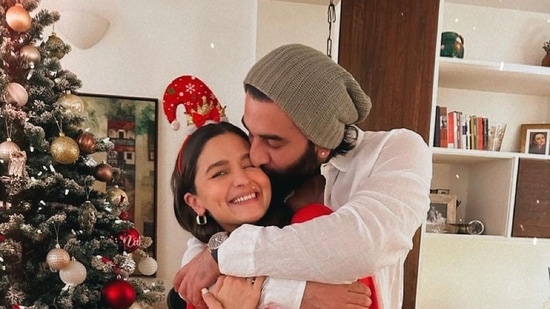 In this adorable photo, Ranbir Kapoor can be seen hugging his wife Alia Bhatt and giving her a peck on her cheeks near the Christmas tree.&nbsp;(Instagram/@aliaabhatt)