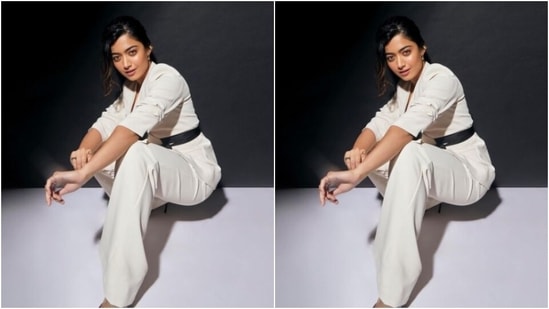 In a white wrap around coat with a black belt and a pair of white formal trousers, Rashmika rounded off her look with shiny black stilettos with pointed details. (Instagram/@rashmika_mandanna)