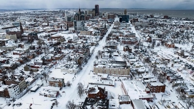 An aerial view of houses blanketed in snow in Buffalo, on December 25. Those who lost their lives around Buffalo were found in cars, homes and snowbanks, AP reported. (Joed Viera / AFP)