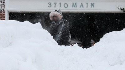 A woman clears snow from her driveway in Buffalo, on December 26. Scientists say the climate change crisis may have contributed to the intensity of the storm. That's because the atmosphere can carry more water vapour, which acts as fuel, Mark Serreze, director of the National Snow and Ice Data Center at the University of Colorado, Boulder told AP. (Brendan McDermid / REUTERS)