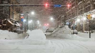 Vehicles are seen abandoned in heavy snowfall in downtown Buffalo, on December 26. According to the tracking site FlightAware, some 3,410 domestic and international flights were cancelled on December 26 as of about 3 p.m. EDT, AP reported. (Joed Viera / AFP)
