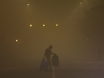 A man walks across a smoggy road on a cold winter morning in Delhi.