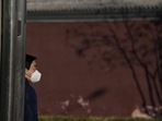 Covid In Japan, Hong Kong, Taiwan: A resident wears a mask as he stands near the shadow of a tree.(AP) Covid In Japan, Hong Kong, Taiwan: A resident wears a mask as he stands near the shadow of a tree.(AP)