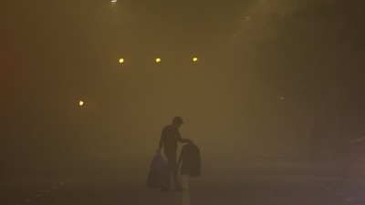 A man walks across a smoggy road on a cold winter morning in Delhi. (REUTERS)