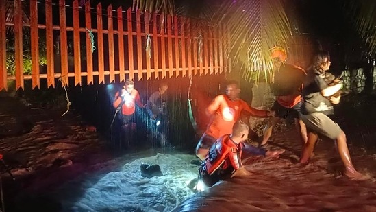 Philippine Coast Guard rescuers evacuate people from a flooded area in Ozamiz City, Misamis Occidental on December 25. Nearly 400,000 people were affected, with over 81,000 still in shelters and nine others injured, the National Disaster Risk Reduction and Management Council told AP. (Philippine Coast Guard / AFP)