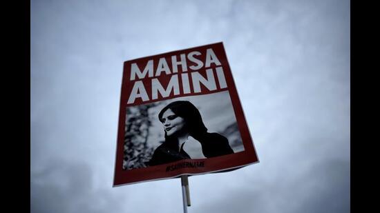 A woman holds a placard with a picture of Iranian woman Mahsa Amini during a protest against her death, in Berlin, Germany on September 28, 2022. (AP Photo/Markus Schreiber, File)