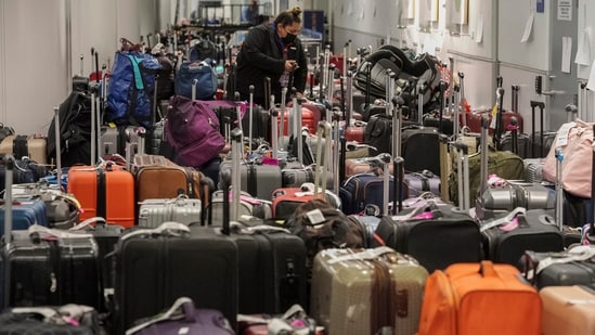 Southwest Airlines employees sort suitcases near the baggage carousel at Los Angeles International Airport Tuesday, Dec. 27, 2022, after Southwest Airlines flights were canceled and delayed during a winter storm.  AP/PTI