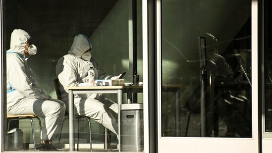 Covid In China: Security guards wearing personal protective equipment (PPE) amid the Covid-19 pandemic sit at an entrance of a building in Beijing.(AFP)