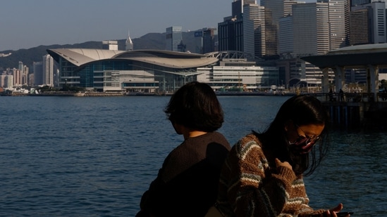 People wearing face masks sit by the sea during the coronavirus disease (Covid-19) pandemic in Hong Kong, China, December 28, 2022. China to finally lift Covid-19 travel restrictions after 3 years of coronavirus lockdown (REUTERS/Tyrone Siu)