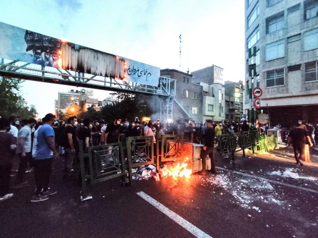 Iranian demonstrators burning a rubbish bin in the capital Tehran during a protest for Mahsa Amini, days after she died in police custody. (AFP)
