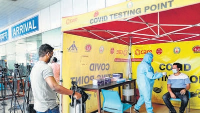 A medic takes swab sample from a passenger for Covid-19 test at Chennai airport on Saturday. (PTI) A medic takes swab sample from a passenger for Covid-19 test at Chennai airport on Saturday. (PTI)