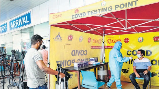 A medic takes swab sample from a passenger for Covid-19 test at Chennai airport on Saturday. (PTI)