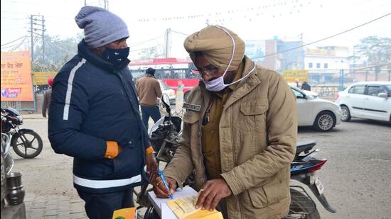 Traffic police personnel challaning a violators in Ludhiana. (Harvinder Singh/HT) Traffic police personnel challaning a violators in Ludhiana. (Harvinder Singh/HT)