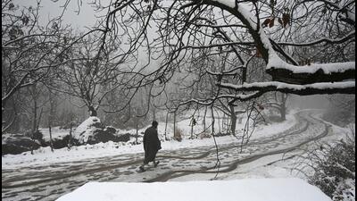 A man walks after fresh snowfall in the outskirts of Srinagar. (Waseem Andrabi/HT)