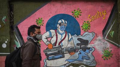A man walks past a mural art of a health worker at New Delhi’s Rajendra Nagar. (HT photo)