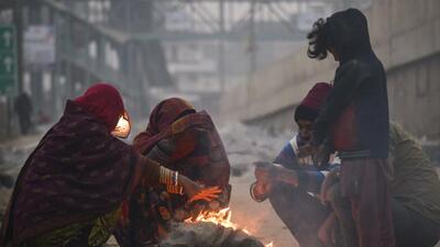 Gurugram, Dec 30 (ANI): People sit around the bonfire to keep themselves warm on a cold winter day, in Gurugram on Friday. (ANI Photo) (Yogendra Kumar)