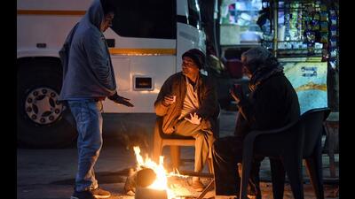 People gather around a bonfire to keep themselves warm on a cold winter morning in New Delhi. (ANI Photo) People gather around a bonfire to keep themselves warm on a cold winter morning in New Delhi. (ANI Photo)