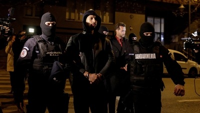 Andrew Tate and Tristan Tate are escorted by police officers outside the headquarters of the Directorate for Investigating Organized Crime and Terrorism in Bucharest (DIICOT) after being detained for 24 hours, in Bucharest, Romania, December 29, 2022. (Reuters)