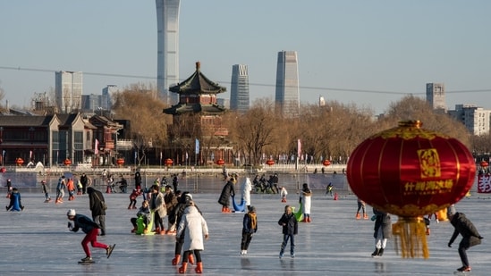 People skate on the frozen Houhai Lake in Beijing, China. China could see as many as 25,000 deaths a day from Covid-19 later in January, casting a shadow over the start of the first Lunar New Year festivities without pandemic restrictions. India, Spain, Malaysia add travel curbs on tourists from China as Covid-19 rises (Bloomberg)