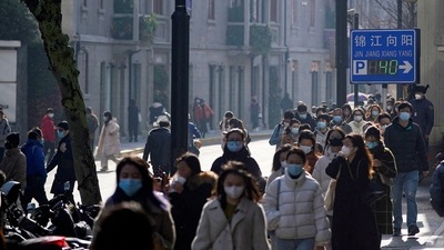 People wearing face masks walk on a street, as coronavirus disease (COVID-19) outbreaks continue in Shanghai, China. (REUTERS file)