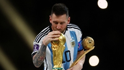 Argentina's Lionel Messi kisses the World Cup trophy after receiving the Golden Ball award as he celebrates after winning the World Cup. (Reuters)