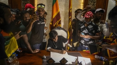 A protester sits at the desk of Sri Lankan Prime Minister Ranil Wickremesinghe after storming his office in Colombo, Sri Lanka on July 13. (AP) A protester sits at the desk of Sri Lankan Prime Minister Ranil Wickremesinghe after storming his office in Colombo, Sri Lanka on July 13. (AP)